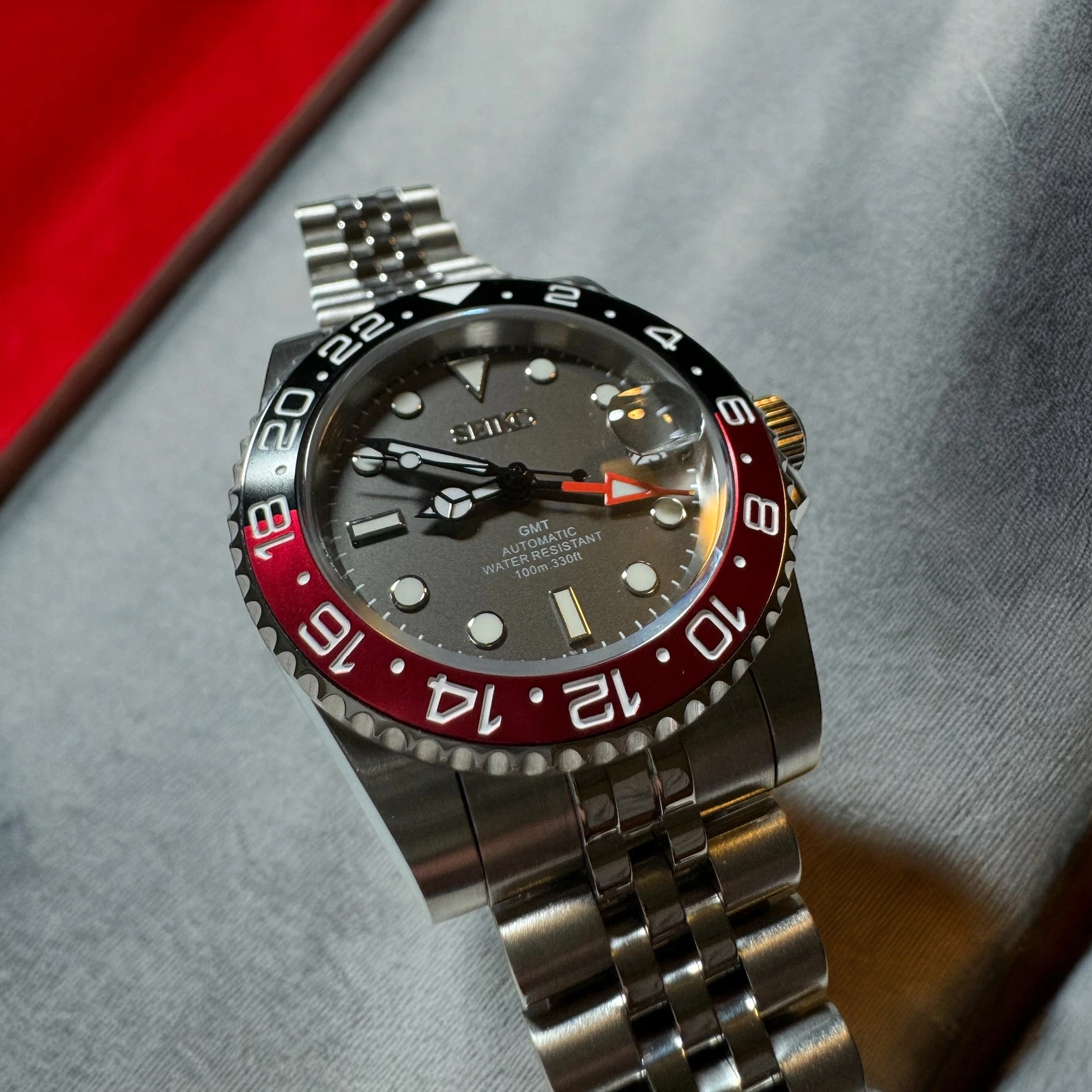 Photograph of a finished AP Custom Watches GMT build with a red and black bezel and metal bracelet