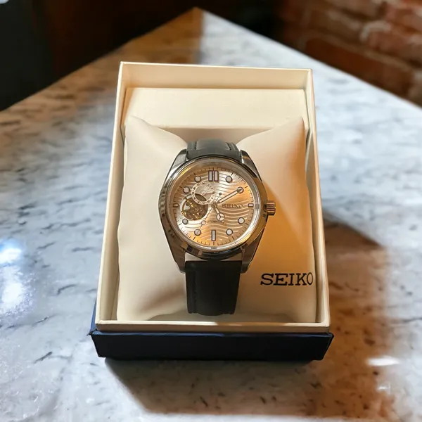 Pearl-style open-heart watch with a 24-hour subdial in its box